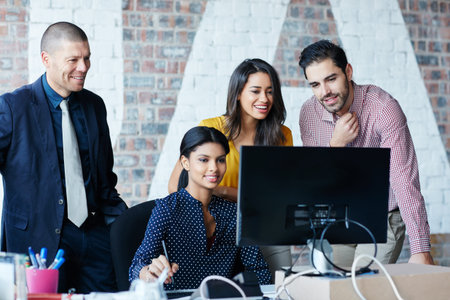 Pooling their skills. four businesspeople working in the office.