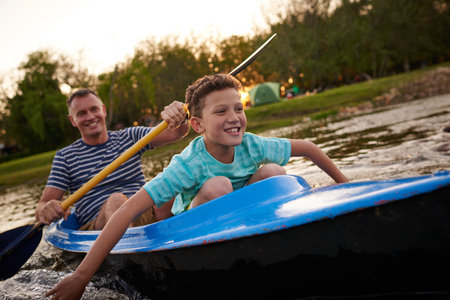Theyre an adventurous father and son. a father and son rowing a boat together on a lake.の写真素材