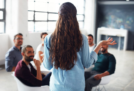 The creative process. Rearview shot of a woman giving a presentation to colleagues in an office.