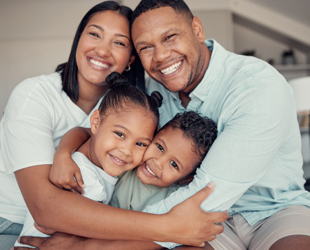 Happy, smile and portrait of family hugging, bonding and relaxing together in their home. Loving, father and mother holding their children with love, care and happiness in the living room in a house.の写真素材
