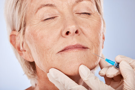 Botox, beauty and senior woman face with hyaluronic acid injection for anti aging, collagen dermal filler or facial skincare. Plastic surgery, aesthetic and hands of plastic surgeon doing face liftの写真素材