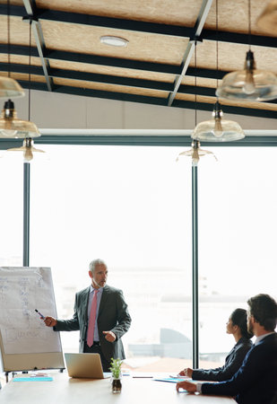 Putting their minds to task. a group of executives having a meeting in a boardroom.
