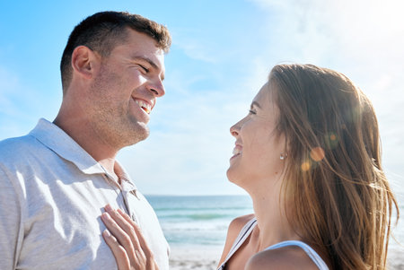 Smile, love and couple at the beach while on holiday or romantic summer honeymoon in greece. Happy, care and calm man and woman with romance, embracing and bonding in nature by the ocean on vacationの写真素材