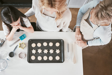 Baking, learning and cookies with family on kitchen counter with girl, mother and grandmother in...