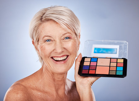 Makeup, senior and woman portrait smile with beauty, cosmetic and color eyeshadow product. Elderly model face happy with skincare, cosmetics and colorful eye palette for cosmetology and self careの写真素材