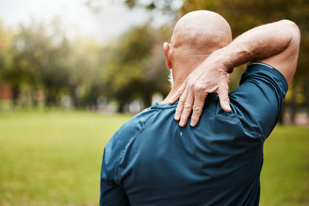 Exercise, fitness and back pain of senior man at outdoor park after bad workout. Mature male runner...