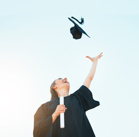 Woman celebrate graduation hat in blue sky for success, achievement and goals of university...