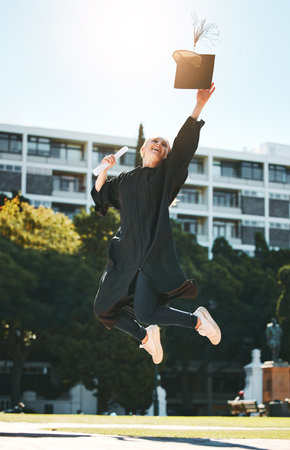 Woman graduation, jump and celebrate at college, school or university with certificate in sunshine. Student graduate, scholarship or diploma in success, celebration or education while happy at campusの写真素材