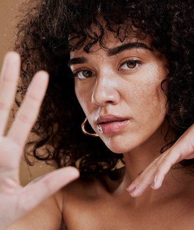 Hand, portrait and woman in studio for skincare, beauty and wellness, sexy and attitude. Face, skin and girl model showing stop hand sign, saying no to ageing and satisfied with natural productの写真素材