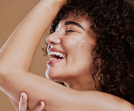 Makeup, woman and skincare for wellness, natural beauty and fresh with brown studio background. Cosmetics, healthy female and girl with organic facial, smooth face, or smile with freckles and happy.の写真素材