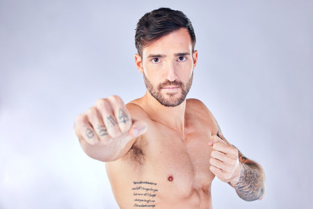 Fitness, sport or man boxer with tattoo in white studio background for health wellness, exercise or training. Motivation, sports focus or male athlete model for power boxing or punching workoutの写真素材