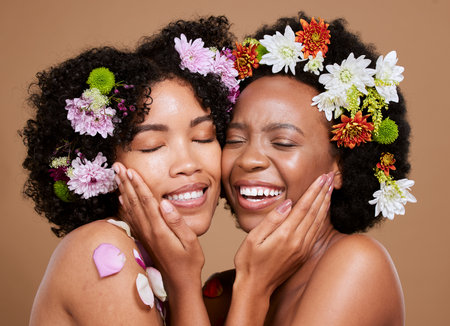 Flower, skincare and African women with support for wellness from dermatology against a brown studio background. Beauty, care and floral model friends with love for flowers and cosmetics with a hugの写真素材