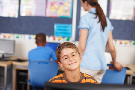 Admiring his work on the computer. A young schoolboy in computer class.の写真素材