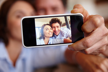 The closeup on commitment. a husband and wife taking a selfie together on a smartphone.