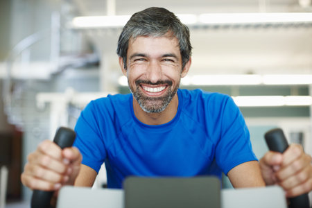 Gotta keep the heart rate up. Cropped portrait of a handsome man using an exercise bike in the gym.