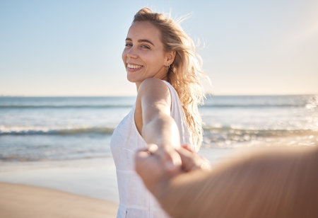 Love portrait, woman pov and holding hands on beach and happy relationship, anniversary and embrace while on holiday together. Romance, man and woman smile, loving and bonding with sunset on vacationの写真素材
