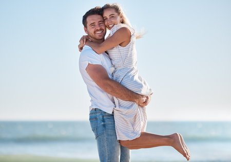 Couple portrait, love and beach holiday, travel and freedom in summer, happy smile and freedom in hawaii. Blue sky, nature and hug with man, woman and vacation together at ocean, sea and happy coupleの写真素材
