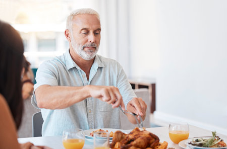 Family, turkey and senior man cut meat for brunch buffet meal, reunion celebration event or feast for hungry people. Elderly person cutting chicken protein food during quality bonding time at lunchの写真素材