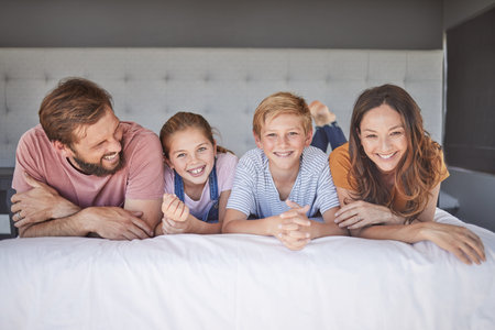 Happy, relax and portrait of a family on a bed for love, peace and calm in their house together....