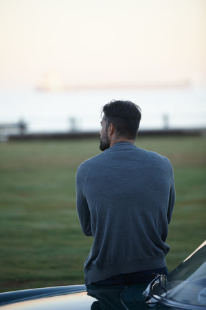 Remember to explore. Rearview shot of a man looking at the view while leaning against his car.の写真素材