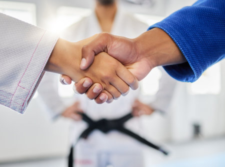 Handshake, karate and sports with a man and woman fighter shaking hands in a gym, club or dojo. Fitness, exercise and thank you with a male and female athlete showing sportsmanship before a fightの写真素材
