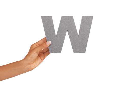 Whats with this W. A young woman holding a capital letter W isolated on a white background.の写真素材