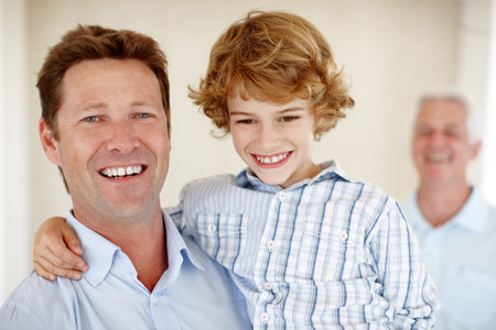 Hes my little superstar. Cropped portrait of a young boy and his father with granddad in the...