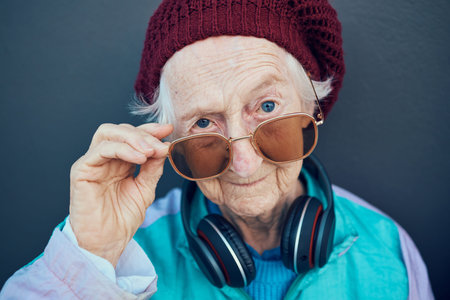 Senior woman, face and fashion sunglasses, vintage and 90s clothes, cool style and headphones with...