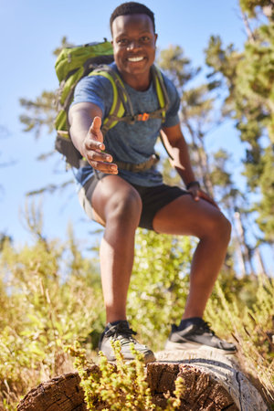 Black man, hiking and help hand, smile and happy outdoor in nature, forest or nature park in summer....