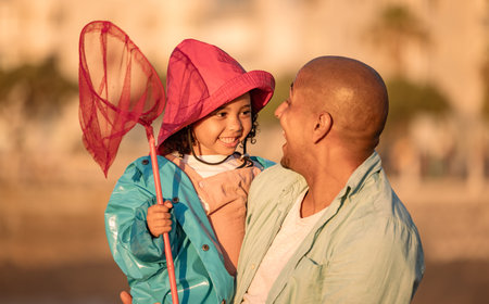 Father, fishing and child on beach for freedom, love and learning to fish in summer together. Excited kid, happy family and teaching girl with fishing net on holiday adventure or vacation outdoorの写真素材