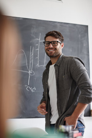Hes sure of his research. a young man presenting information on a blackboard.の写真素材