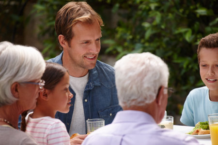 Sharing a meal as a family. a happy multi-generational family having a meal together outside.