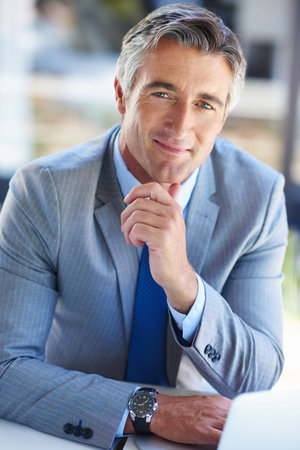 Take opportunity by the horns. Portrait of a confident-looking mature businessman working on a...