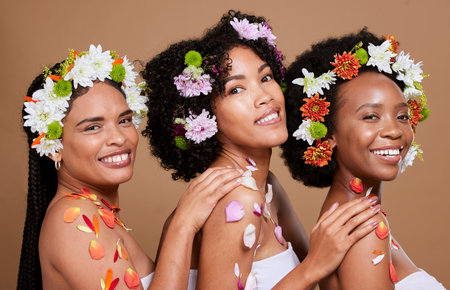 Beauty, skincare and flowers with black women and cosmetic portrait with floral creative design against studio background. Flower aesthetic, wellness and natural cosmetics with nature and self care.の写真素材