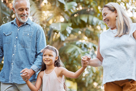 Park, holding hands and grandparents with child for outdoor walking, nature wellness and development...