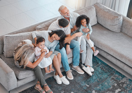 Happy family, children or parents bonding with senior grandparents on sofa in house or home living room. Top view, men or women with kids, girls and retirement elderly people together on lounge couchの写真素材