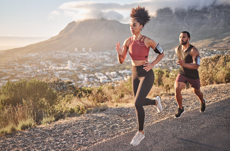 Fitness, exercise and running couple on mountain for cardio workout, training and energy, healthy lifestyle and strong body wellness. Sports, nature and runner man, woman and athletes action on hillの写真素材