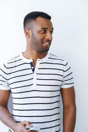 I should probably charge my mobile later...A handsome and casually dressed businessman holding his smartphone while isolated on white.の写真素材