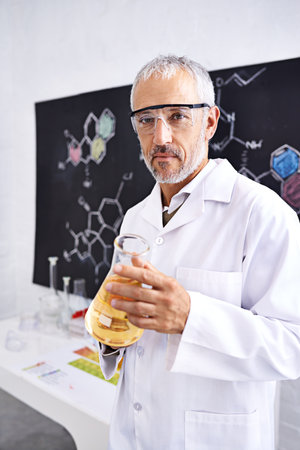 Unraveling chemistry. Portrait of a mature male scientist doing a chemistry experiment in his lab.の写真素材