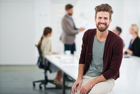 Success is his for the taking. Portrait of a young businessman in an office with colleagues in the background.の写真素材