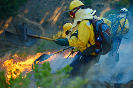 Risk is an everyday part of their job. fire fighters combating a wild fire.の写真素材