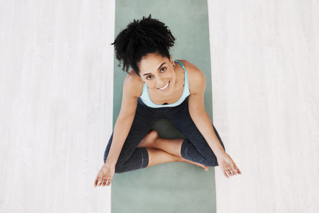 Fitness, yoga and girl portrait top view on ground with mat for wellness, happiness and health. Spirituality, self care and healthy mindset of black woman relaxed on floor for awareness exercise.の写真素材
