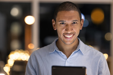 Business man, tablet and happy portrait of a digital fintech employee at night with a smile. Finance project management worker with technology and happiness working on financial software and projectの写真素材