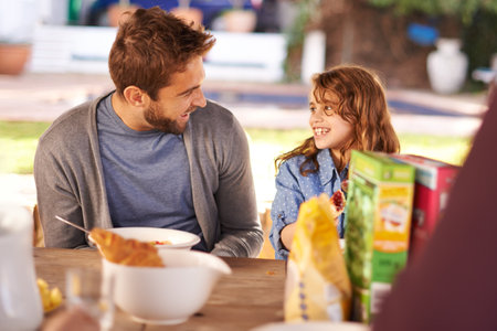 Having a hearty breakfast. a little girl eating breakfast with her dad.の写真素材
