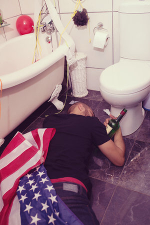 He passed out before he could make it to the toilet. A young man passed out in the bathroom.の写真素材