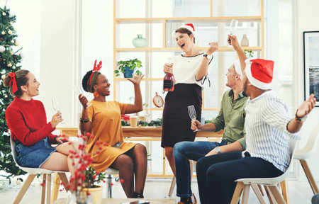 Christmas, party and champagne with business people in office for celebration, merry and festive season. Holiday, xmas and support with employee and wine for diversity, event and content togetherの写真素材