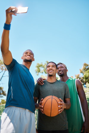 Selfie, basketball and team with phone on court at game, training or practice. Fitness, sports and African athletes taking picture for social media on basketball court after game with mockup space.の写真素材