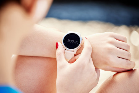 Watch, time and exercise with a sports woman tracking her workout progress with a fitness app closeup. Smartwatch, data and tracker with a female athlete or runner timing her training sessionの写真素材