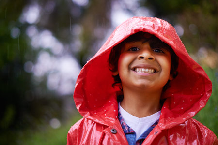 Childhood is the most beautiful of all lifes seasons. an enthusiastic little boy wearing a raincoat...
