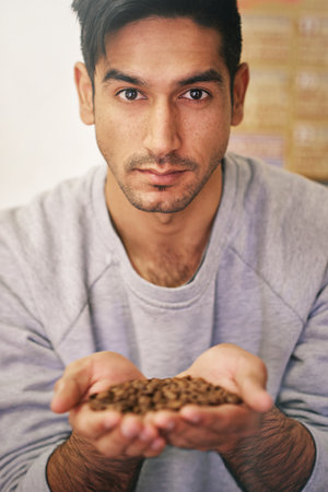 The best beans are brewed by me. Cropped portrait of a young man holding coffee beans.の写真素材